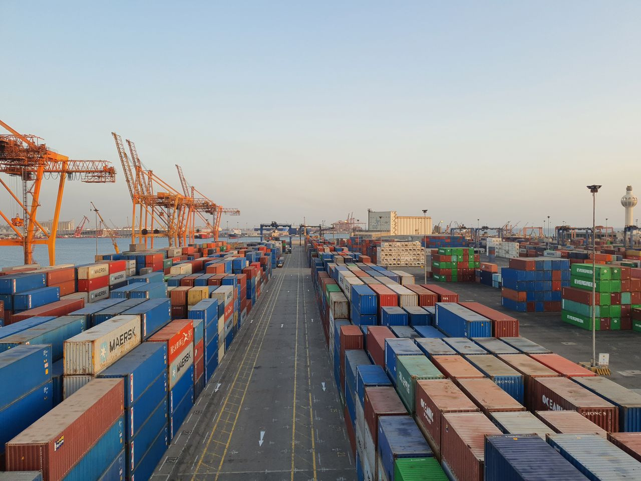 our-story-01 A bustling port scene with colorful cargo containers at sunrise. Ideal for logistics concepts.