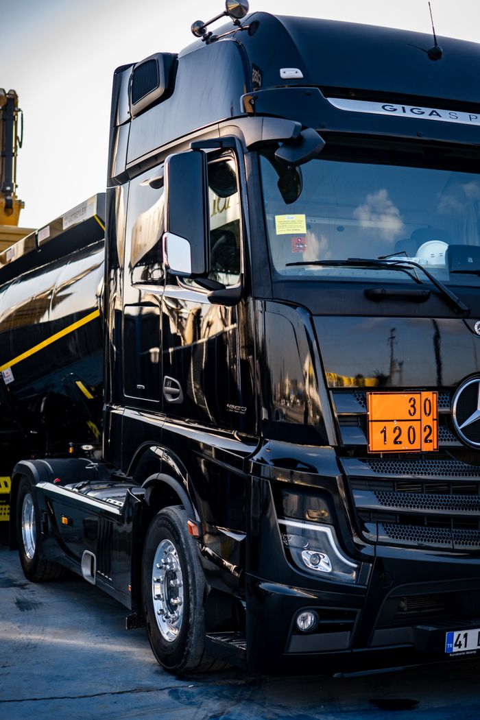services-05 Black truck with a tanker, showcasing logistics and transportation in an industrial environment.