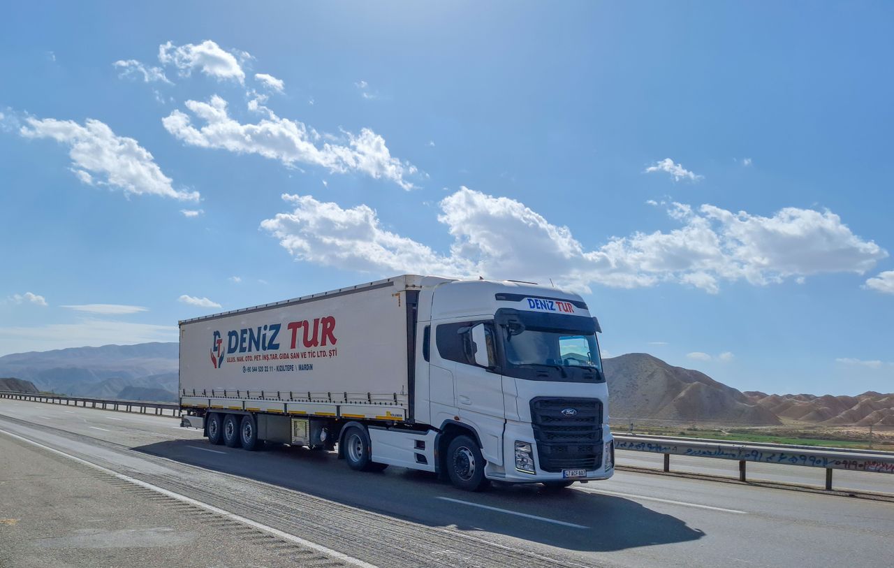 about-06 A Deniz Tur truck travels on a sunny highway in Tabriz, Iran, showcasing logistics on the road.