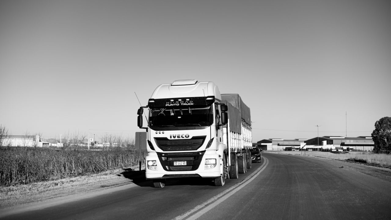 Crafting Captivating Headlines: Your awesome post title goes here Monochrome image of a truck driving on a rural highway, emphasizing urban life.
